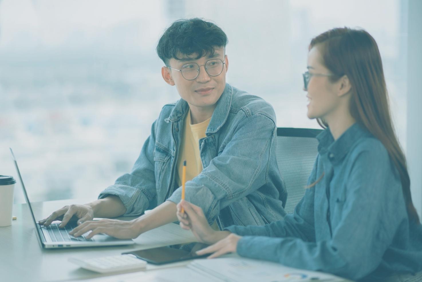 Person arbeitet konzentriert am Computer mit Workshop-Materialien